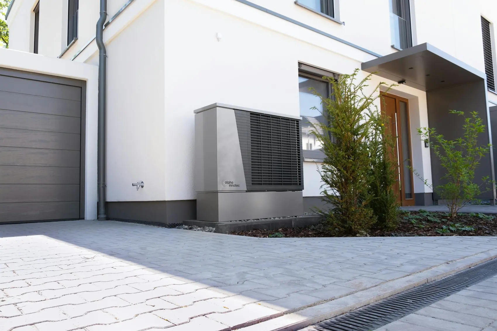 Modern home with an outdoor heat pump unit beside the driveway